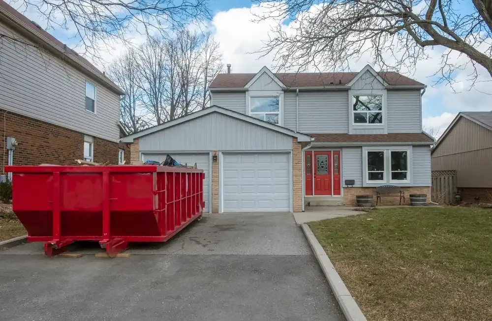 Red dumpster in drive way