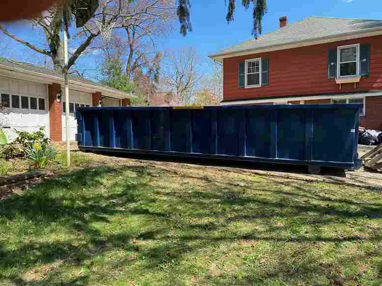 roll off dumpster in front of orange house
