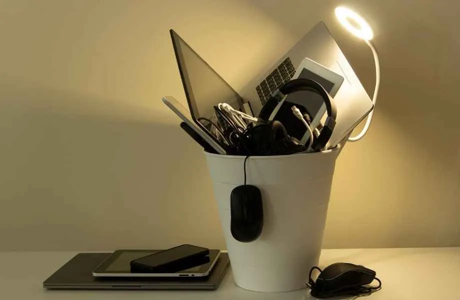 Picture of a trash bin with multiple electronic devices inside