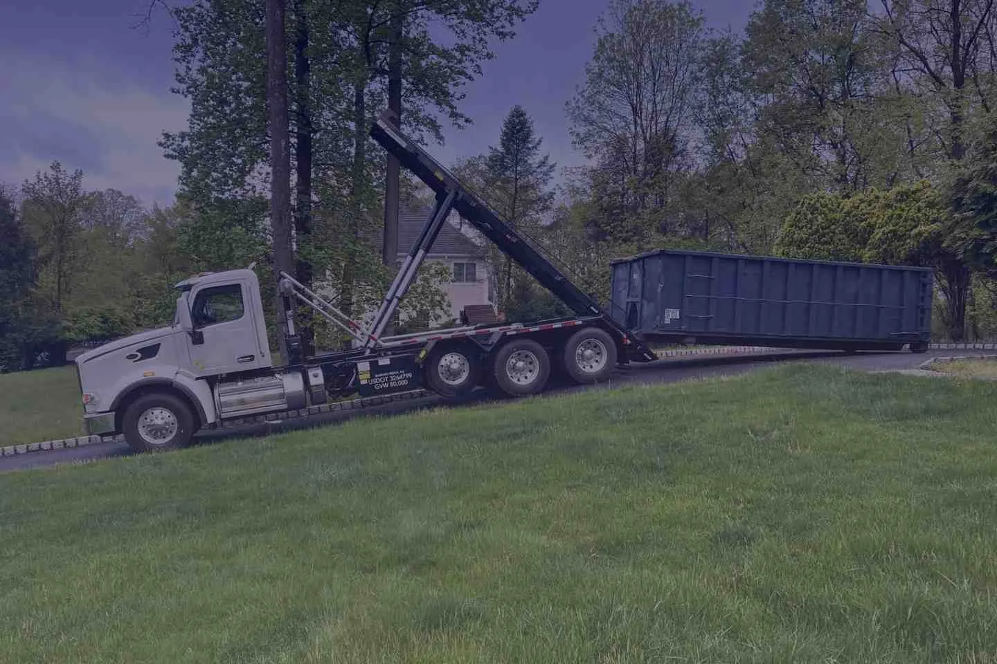 roll off  truck dropping off emergency dumpster on a driveway