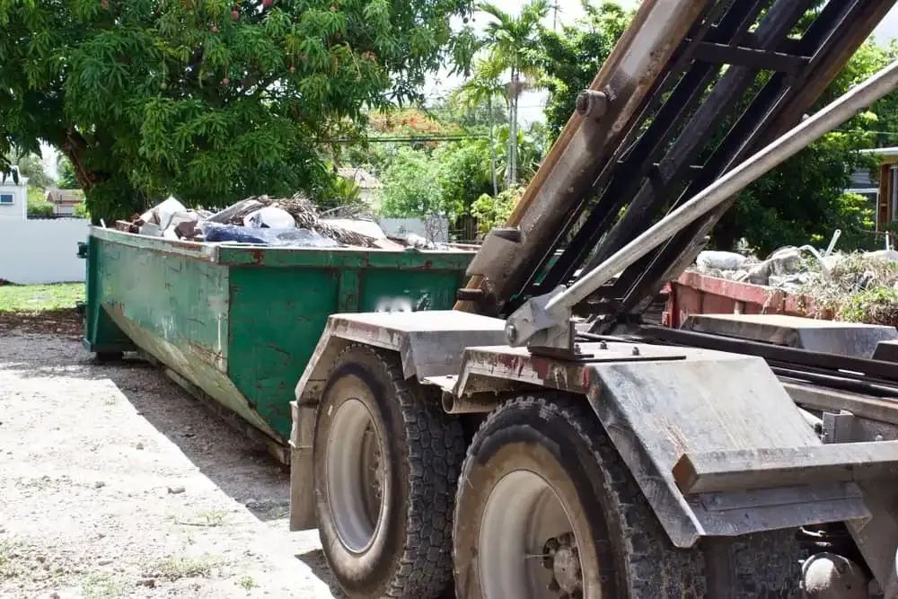 Truck picking up dumpster