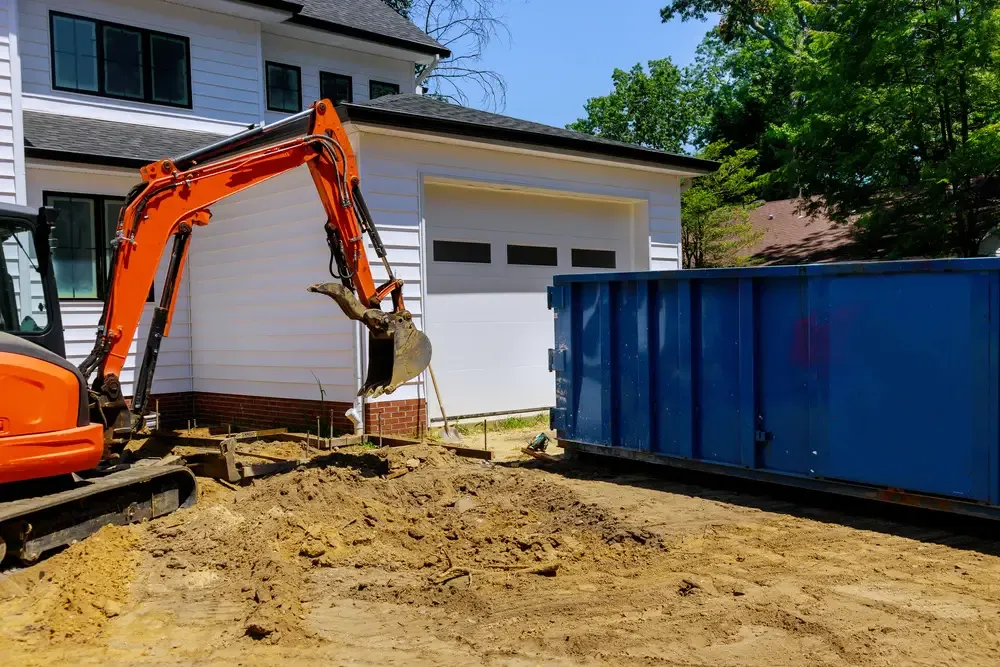 Crane and dumpster in front of house