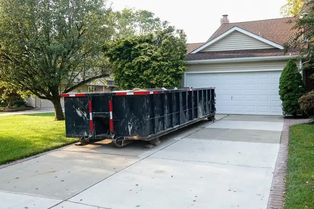 Black dumpster in driveway